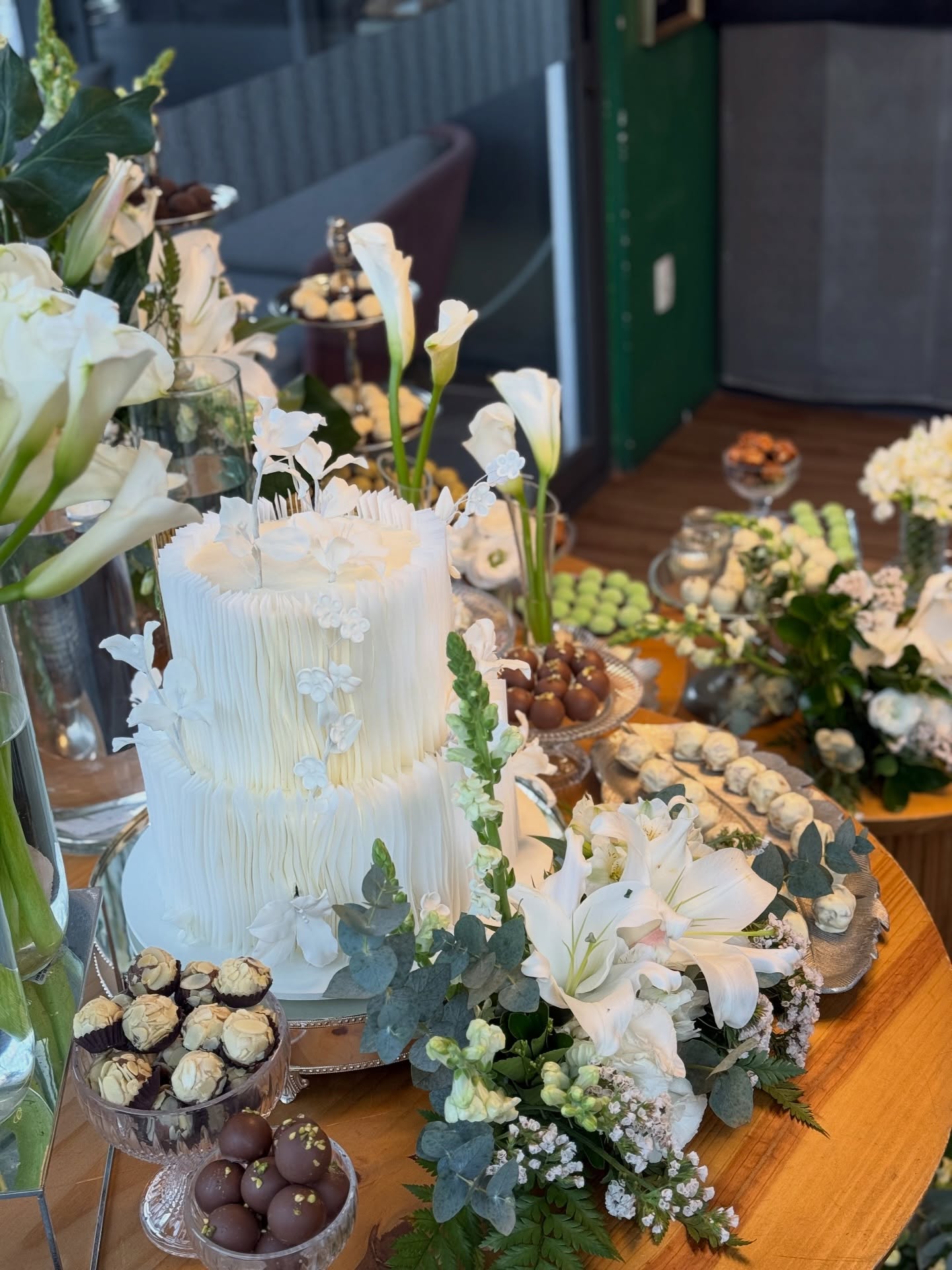 Mesa de casamento com bolo elegante e flores brancas